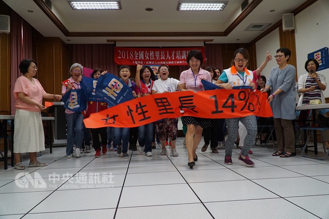 台灣婦女團體全國聯合會20日上午在板橋舉辦「女性里長參選授旗儀式」,多名來自全國各地的女里長參選人,以行動劇方式衝破寫著14%的海報,一起喊出「女人當家,從里做起」的口號(中央社記者林長順攝)